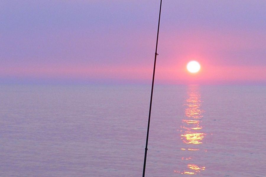夕日を眺めながら釣り糸を垂れる