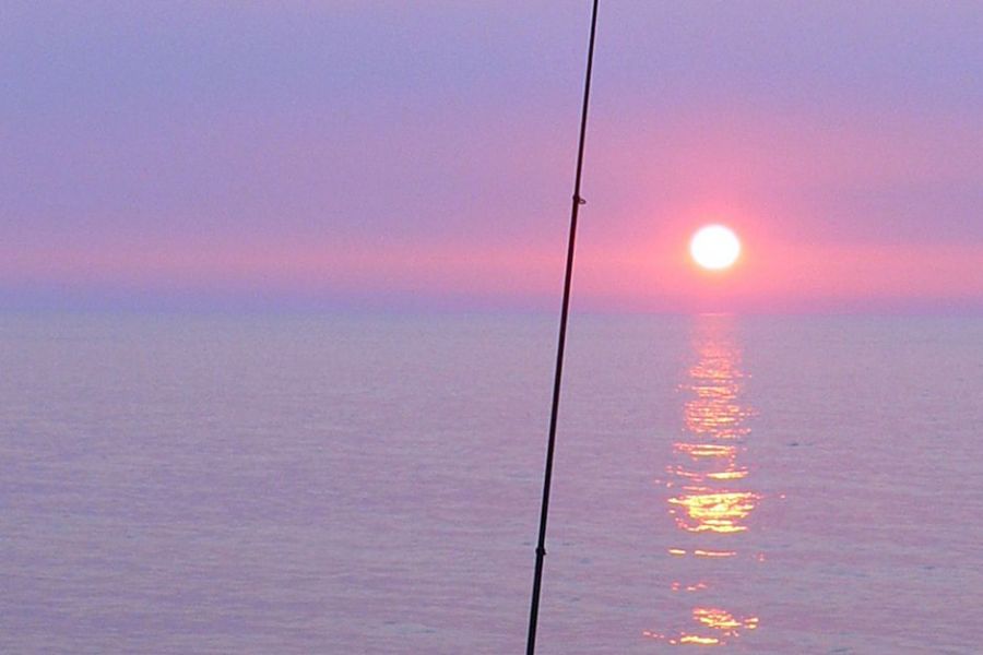 夕日を眺めながら釣り糸を垂れる