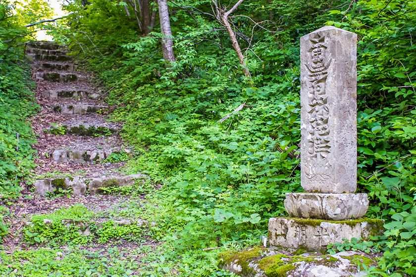 光明仏寺周辺や池の手前には石塔が建っています。