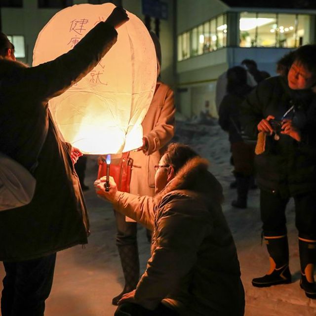 点火スタッフが順次ランタンに火をつけます