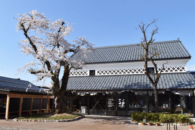 石川雲蝶作の大看板。塩沢宿とサフラン酒本舗、三人のストーリー